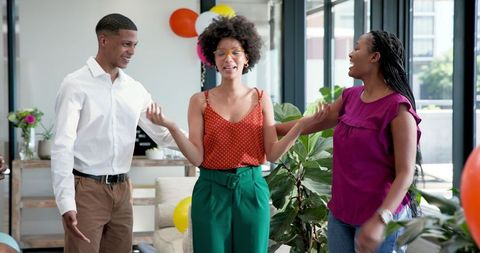 Colleagues Embracing Surprised Coworker at Office Celebration
