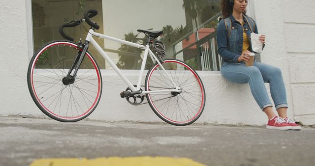 Young Woman Taking a Break with Coffee Next to Bicycle on Urban Street - Download Free Stock Images Pikwizard.com