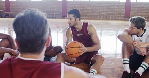 Young basketball players discussing strategy with teammates