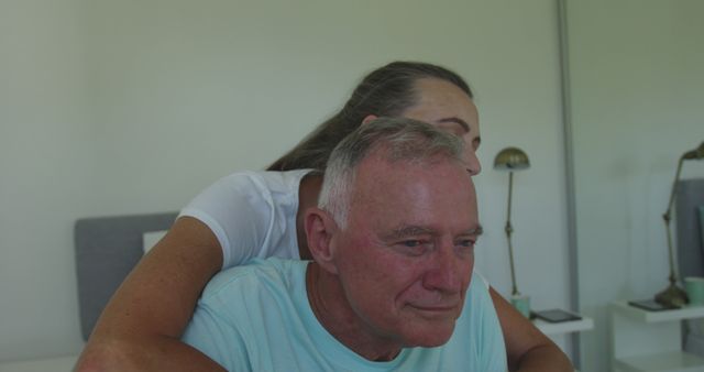 Happy caucasian senior couple embracing sitting on bed. staying at home in isolation during quarantine lockdown.