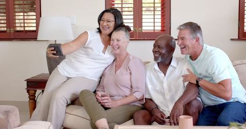 Diverse Group of Friends Taking Selfie on Sofa at Home