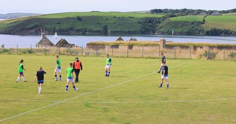 Soccer team training on scenic field near tranquil waters