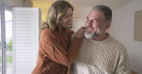 Happy Couple Relaxing Indoors in Cozy Cable Knit Sweaters