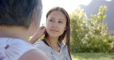 Young Woman Engaging in Conversation Outdoors with Elderly Relative
