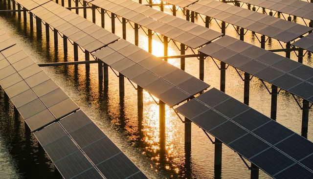 Glinting solar array over reservoir reflecting golden light in geometric diagonal rows