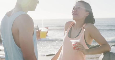 Happy Couple Enjoying Summertime Drinks by the Seaside
