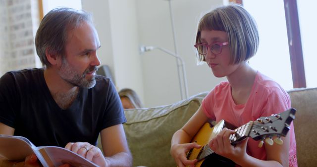 Father and Daughter Playing Guitar Together At Home - Download Free Stock Images Pikwizard.com