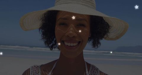 Smiling Woman with Straw Hat Enjoying Sunny Beach Day