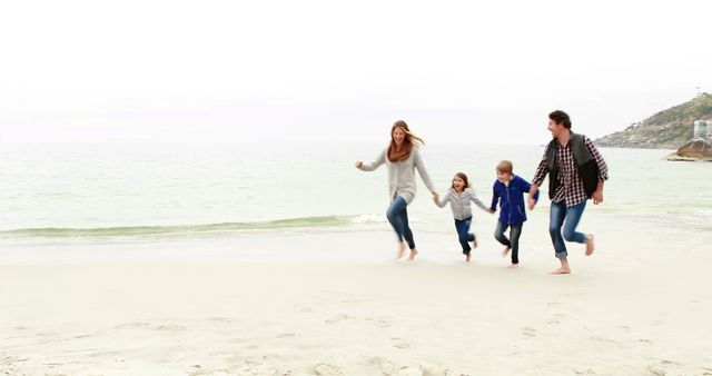Family of four running on sandy beach, holding hands and smiling. Perfect for travel and tourism promotions, family bonding advertisements, or summer vacation brochures.