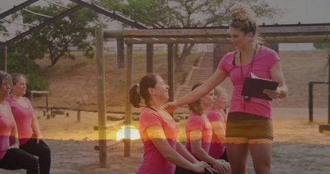 Outdoor fitness bootcamp with energetic instructor motivating group