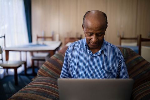 Senior African American Man with Laptop in Cozy Living Space