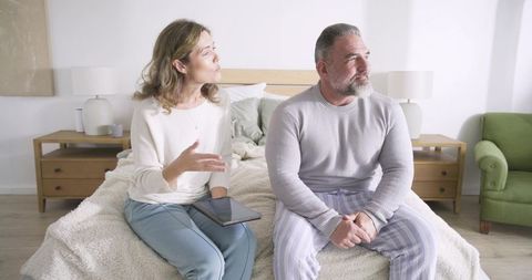 Couple Relaxing in Cozy Bedroom with Tablet