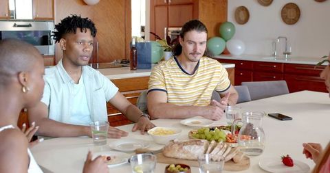 Friends planning party in kitchen with enthusiasm and engagement