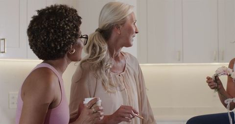 Women Collaborating on Wedding Plan in Modern Kitchen Setting