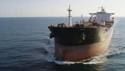 Massive oil tanker cutting through open ocean showing bulbous bow and deck piping