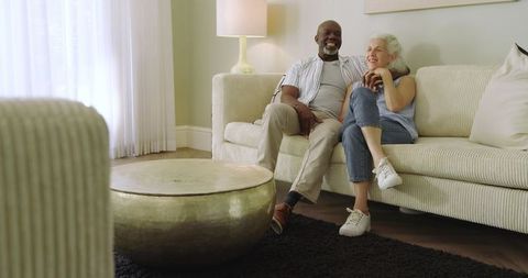 Senior Couple Embracing at Home on Comfortable Sofa