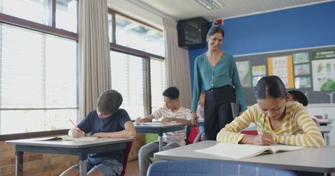 Teacher Observing Diverse Students in Classroom Engaged in Learning