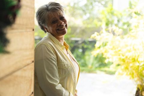 Senior Woman Smiling Brightly in Sunlit Garden