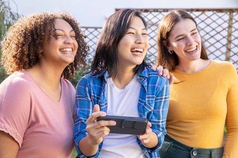 Diverse Friends Enjoying Smartphone Game Outdoors