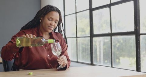Woman Relaxing with White Wine by Sunlit Window