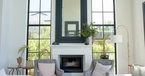 Contemporary cozy living room showcasing fireplace, black mirror and pale pink pillows