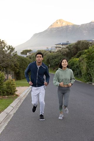 Diverse Couple Jogging in Scenic Mountain Area for Fitness