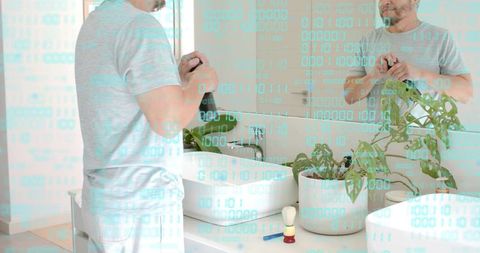 Mature asian man grooming at modern bathroom vanity in light gray tee with binary code overlay
