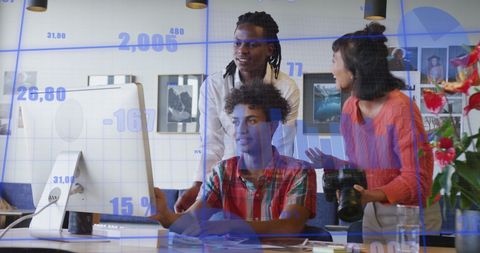 Diverse Team Analyzing Business Data on Computer in Modern Office