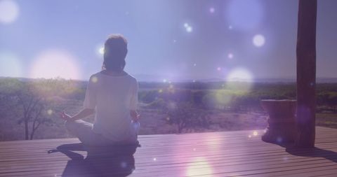 Woman Meditating at Serene Forest Vista with Lens Flare