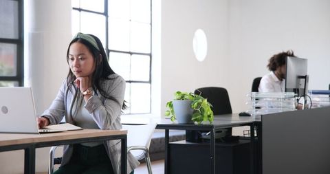 Focused Asian Professional Working at Modern Office Desk
