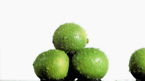 Fresh Limes Dripping with Water on White Background