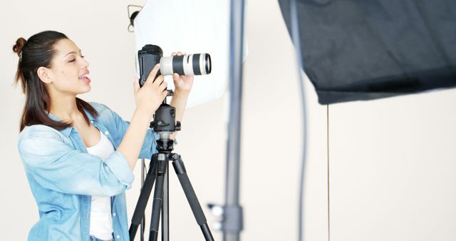 Female Photographer Adjusting Camera in Studio Setting - Download Free Stock Images Pikwizard.com