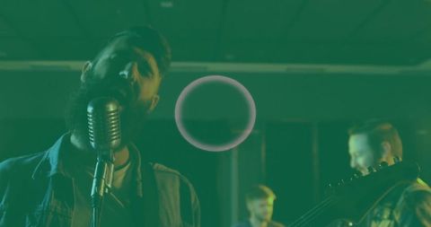 Bearded singer performing in studio with vintage microphone