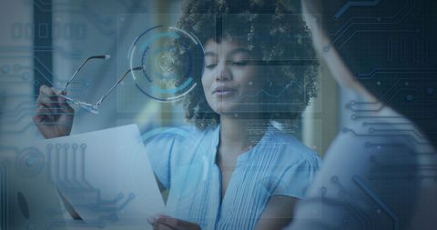 Diverse Businesswomen Analyzing Data with Digital Interface Overlay
