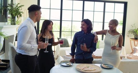 Sunlit modern living room gathering with diverse friends in formal attire chatting