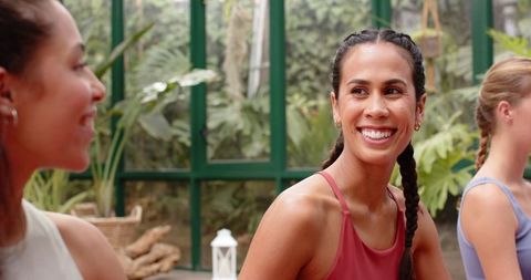 Diverse Group of Women Practicing Yoga in Glass House, Relaxation and Wellness