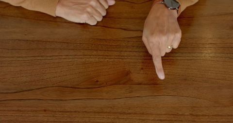 Hands Gesturing on Wooden Table for Casual Home Discussion