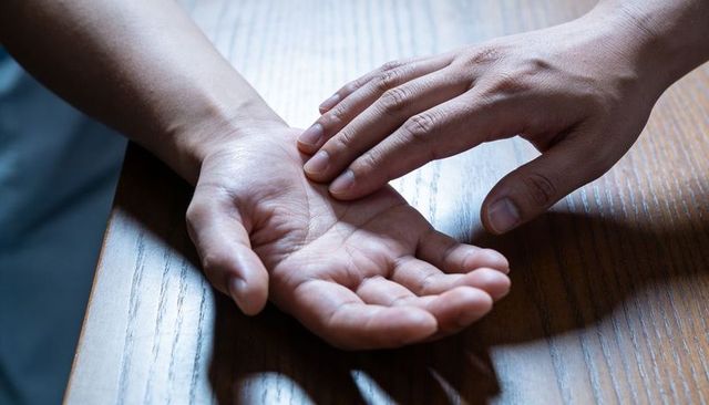 Checking pulse on wrist with gentle touch conveying caregiving support and connection