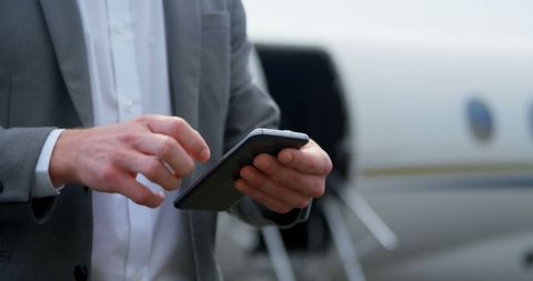 Businessman Using Smartphone at Airport for Efficiency - Download Free Stock Images Pikwizard.com