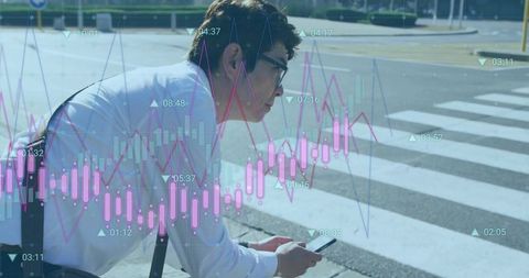Businessman crouching at crosswalk checking smartphone with overlaid financial charts