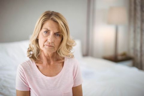 Senior Woman Enjoying Relaxation in Cozy Bedroom Environment