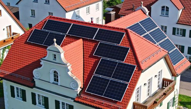 Solar panels on red clay roof of traditional european house showing sustainable home energy