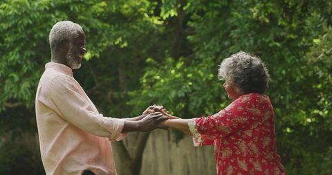 Joyful Senior Couple Dancing in Lush Garden