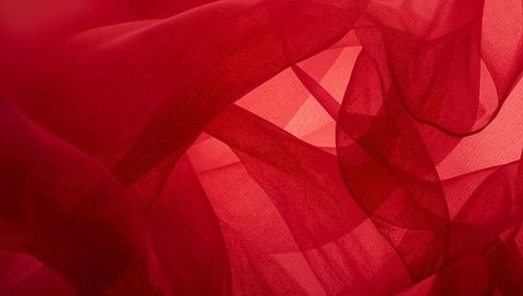 Flowing crimson chiffon layers creating translucent abstract folds and soft light textures