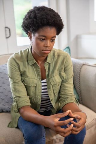 Thoughtful african american woman relaxing at home in natural light