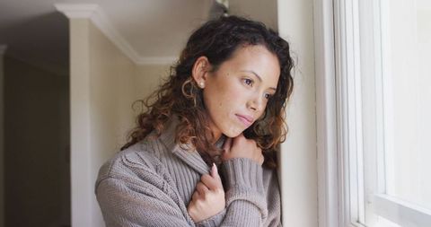 Brooding Woman Contemplating at Home in Cozy Sweater