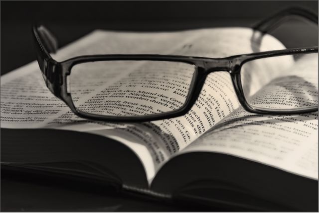Close up shot of glasses over open bible book. Christianity and religion concept