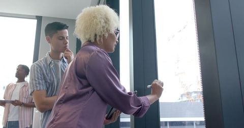 Diverse Team Collaborating on Glass Board in Office