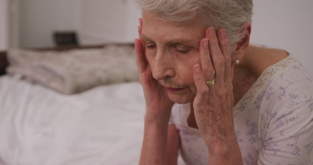 Senior Woman Sitting on Bed with Head in Hands - Download Free Stock Images Pikwizard.com