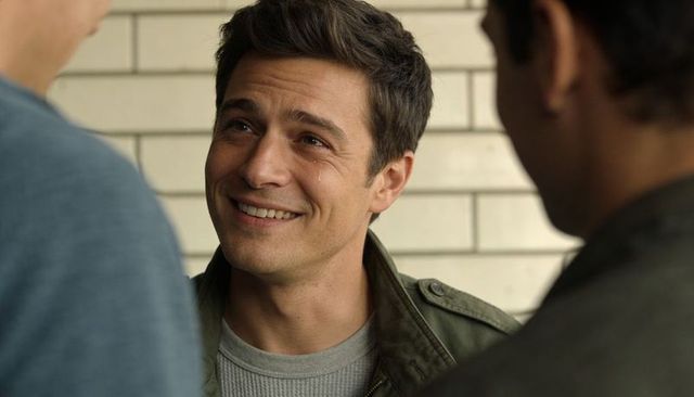 Smiling man with tear conveying relief and warmth in casual green jacket portrait
